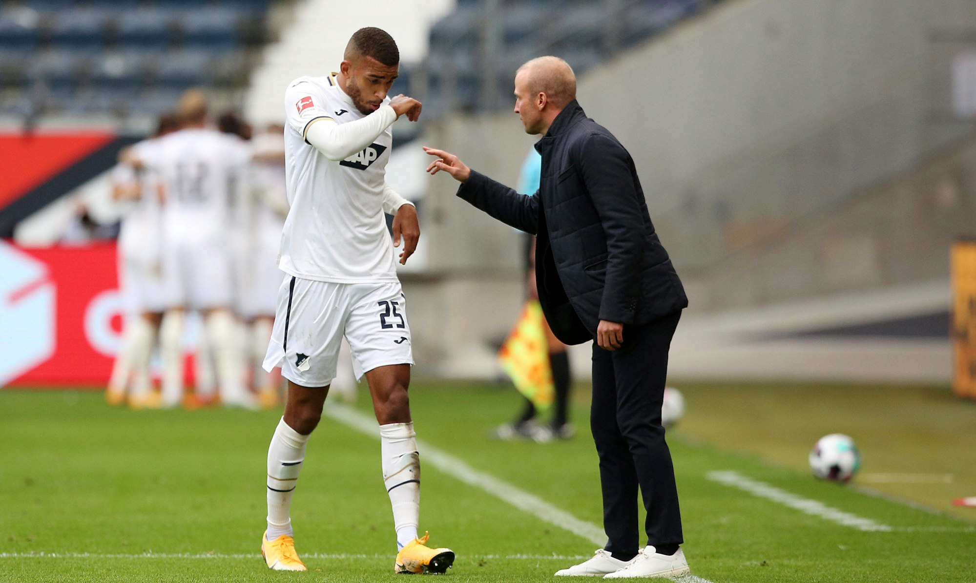 Trainer Sebastian Hoeneß gibt seinem Spieler Akpoguma Anweisungen am Spielfeldrand.