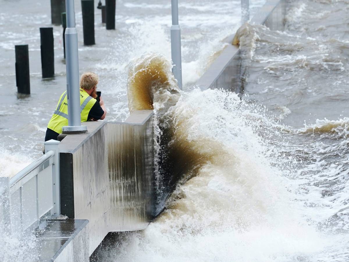 Ein Arbeiter eines Versorgungsunternehmens fotografiert am 29.08.2021 die Wellen, die in Bay Saint Louis, Missouri, gegen eine Ufermauer im städtischen Jachthafen schlagen, während die äußeren Bänder des Hurrikans Ida eintreffen