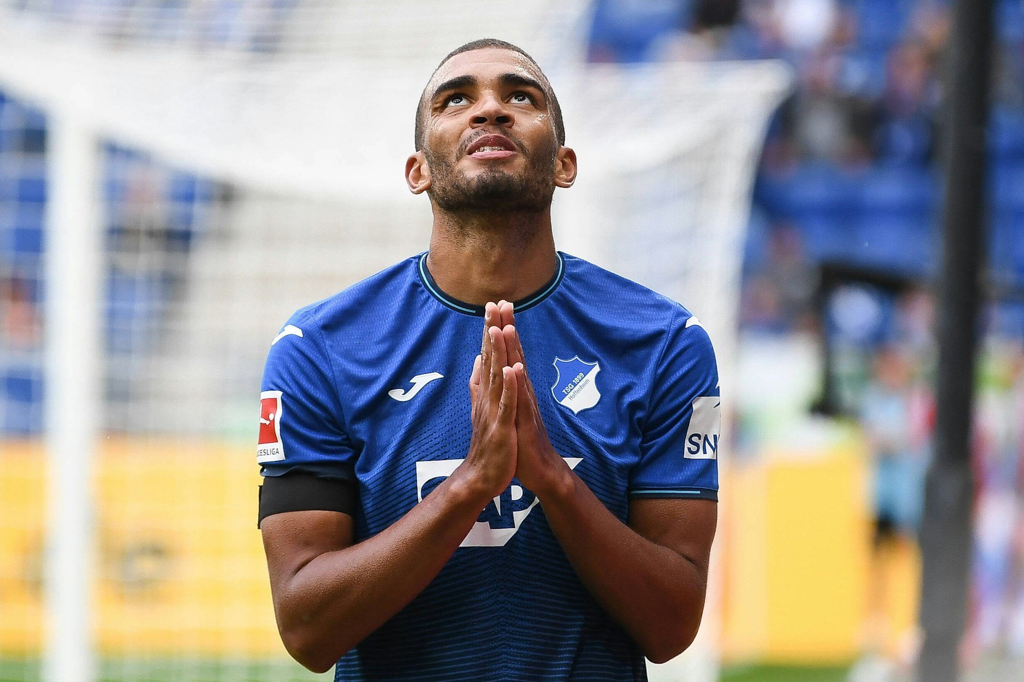 Akpoguma faltet die Hände und richtet seinen Blick Richtung Himmel.