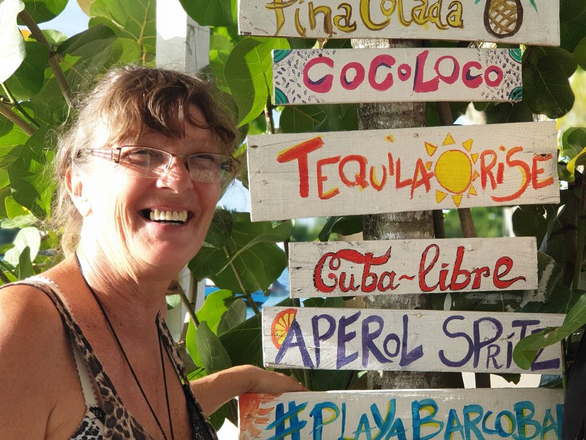 Goodbye Deutschland: Sonja Schröter steht mit ihrer Tochter Nena neben einer Palme, an welcher eine Cocktailkarte genagelt ist.