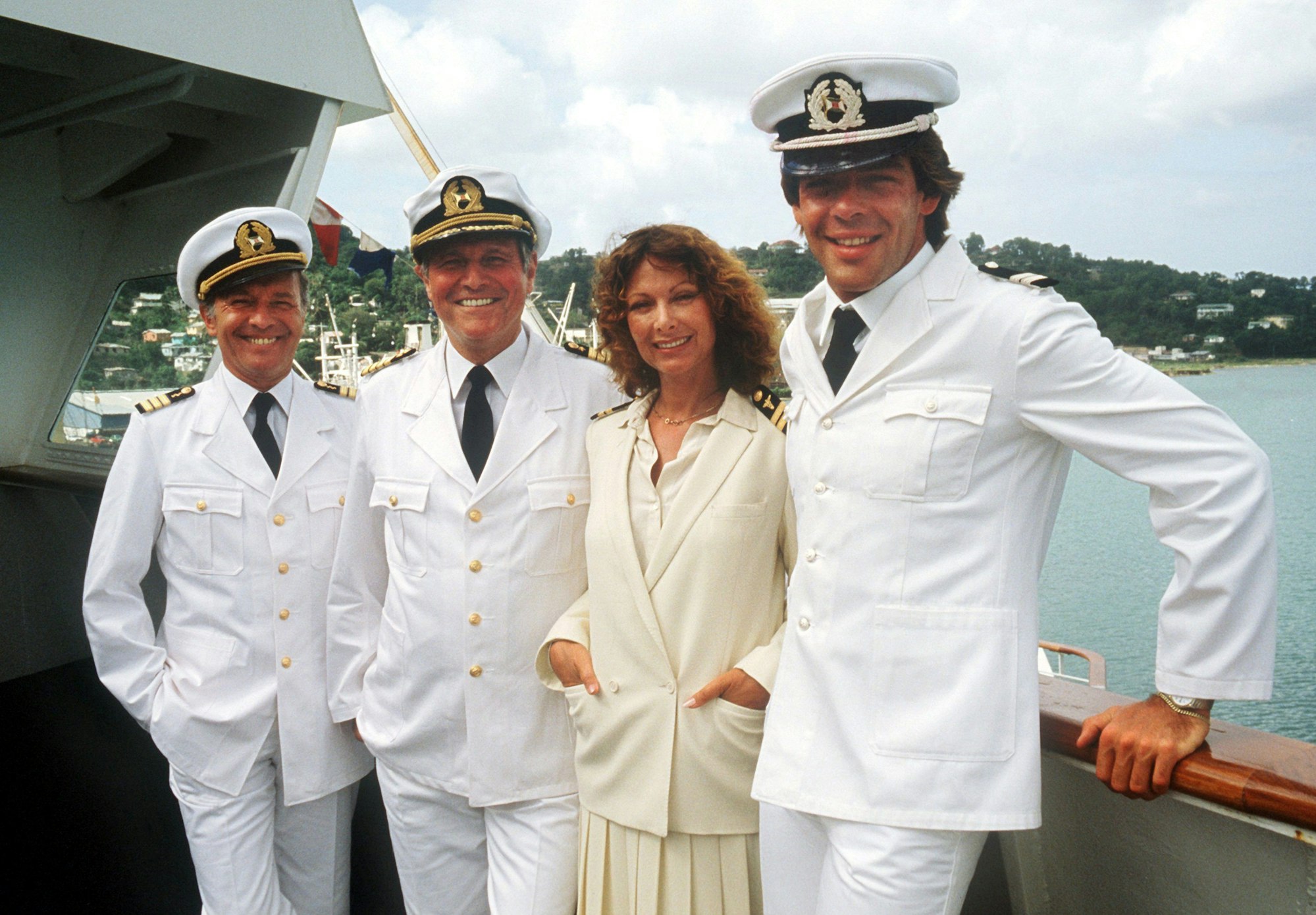 ARCHIV - 30.11.1982, Rheinland-Pfalz, Mainz: Die "Traumschiff"-Crew von 1983 (l-r) Horst Naumann als Schiffsarzt, Heinz Weiss als Kapitän, Heide Keller als Stewardess und Sascha Hehn als Steward.