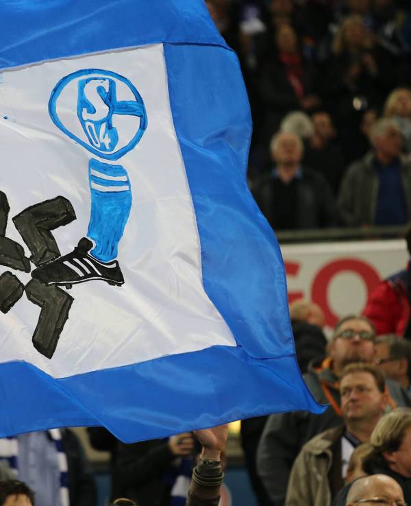 Auf einer Fahne ist ein Schalke-Wappen und ein Fuß zu sehen. Der Fuß zertritt ein Hakenkreuz.