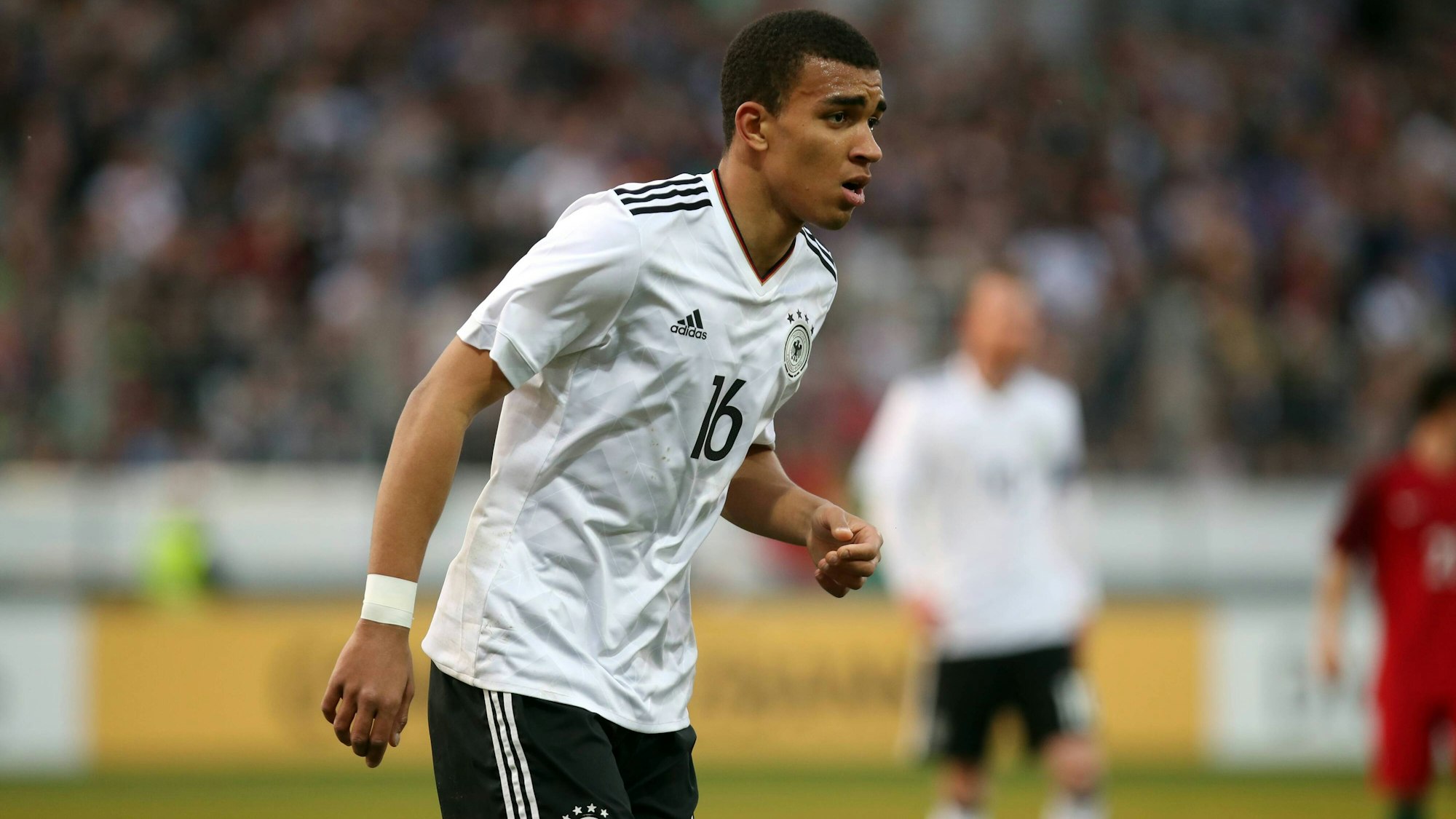 Akpoguma geht angestrengt über das Feld und beugt sich leicht nach vorne.