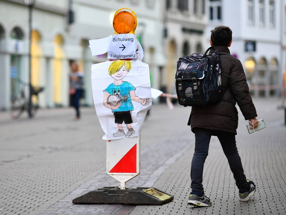 Ein Junge geht am 04.10.2017 in Heidelberg (Baden-Württemberg) in der Hauptstraße an einer Straßenabsperrung mit Absperrband vorbei, an der ein Zettel mit der Aufschrift „Schulweg “angebracht ist.