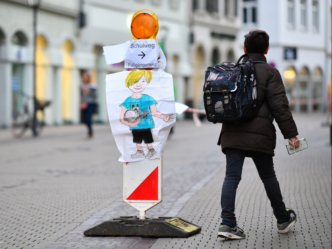 Ein Junge geht am 04.10.2017 in Heidelberg (Baden-Württemberg) in der Hauptstraße an einer Straßenabsperrung mit Absperrband vorbei, an der ein Zettel mit der Aufschrift „Schulweg “angebracht ist.