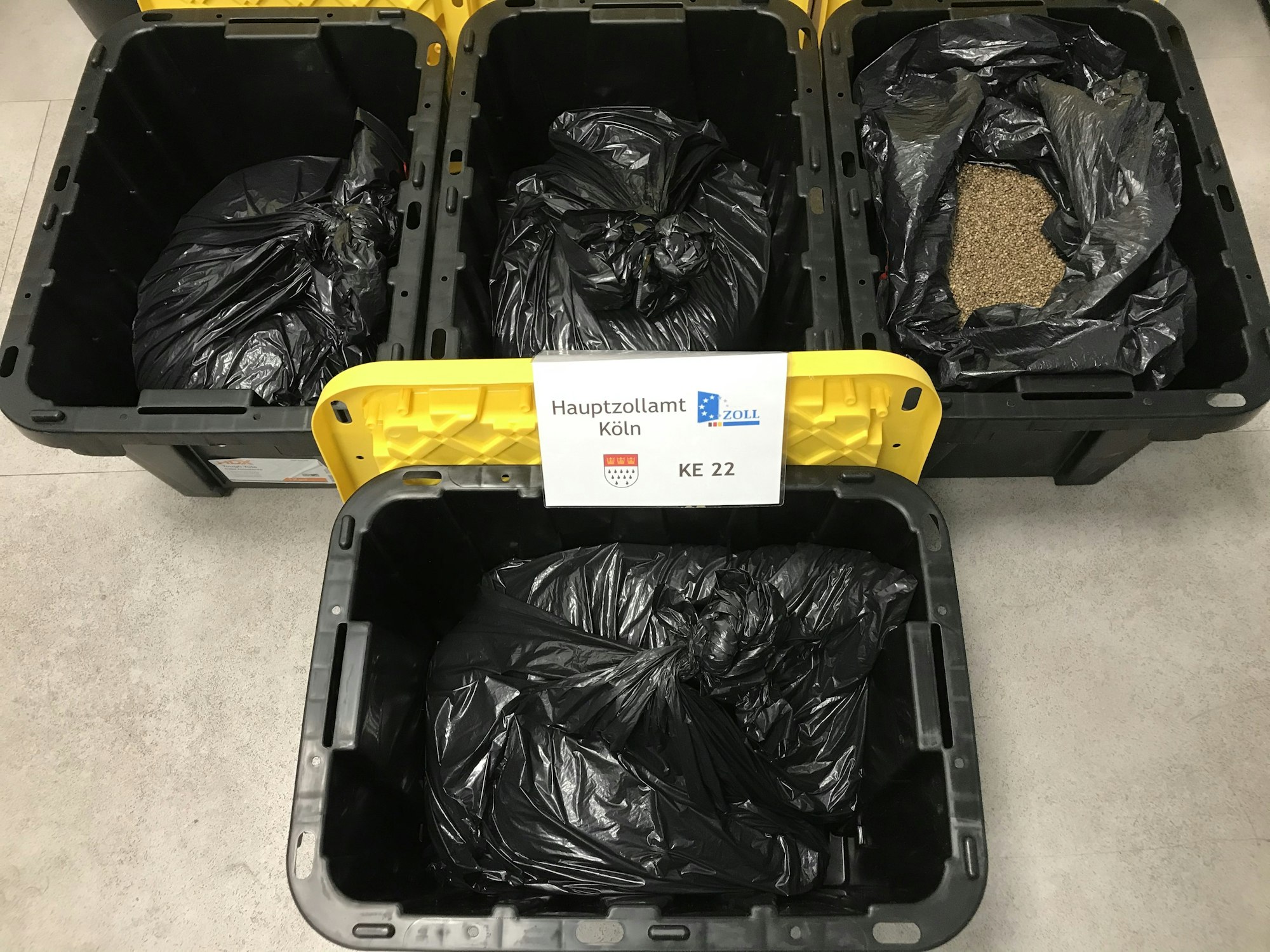 In vier schwarzen Transportboxen befinden sich schwarze Müllsäcke mit den Cannabissamen.