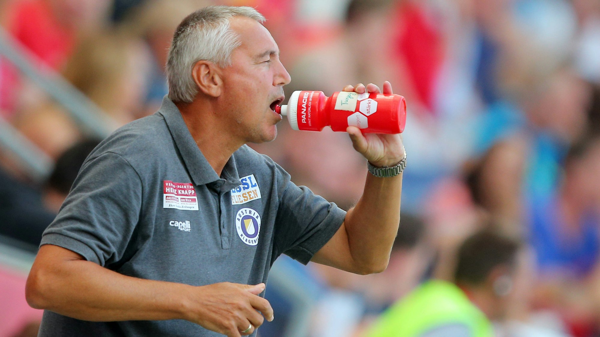 Peter Pacult trinkt am Spielfeldrand aus einer Flasche