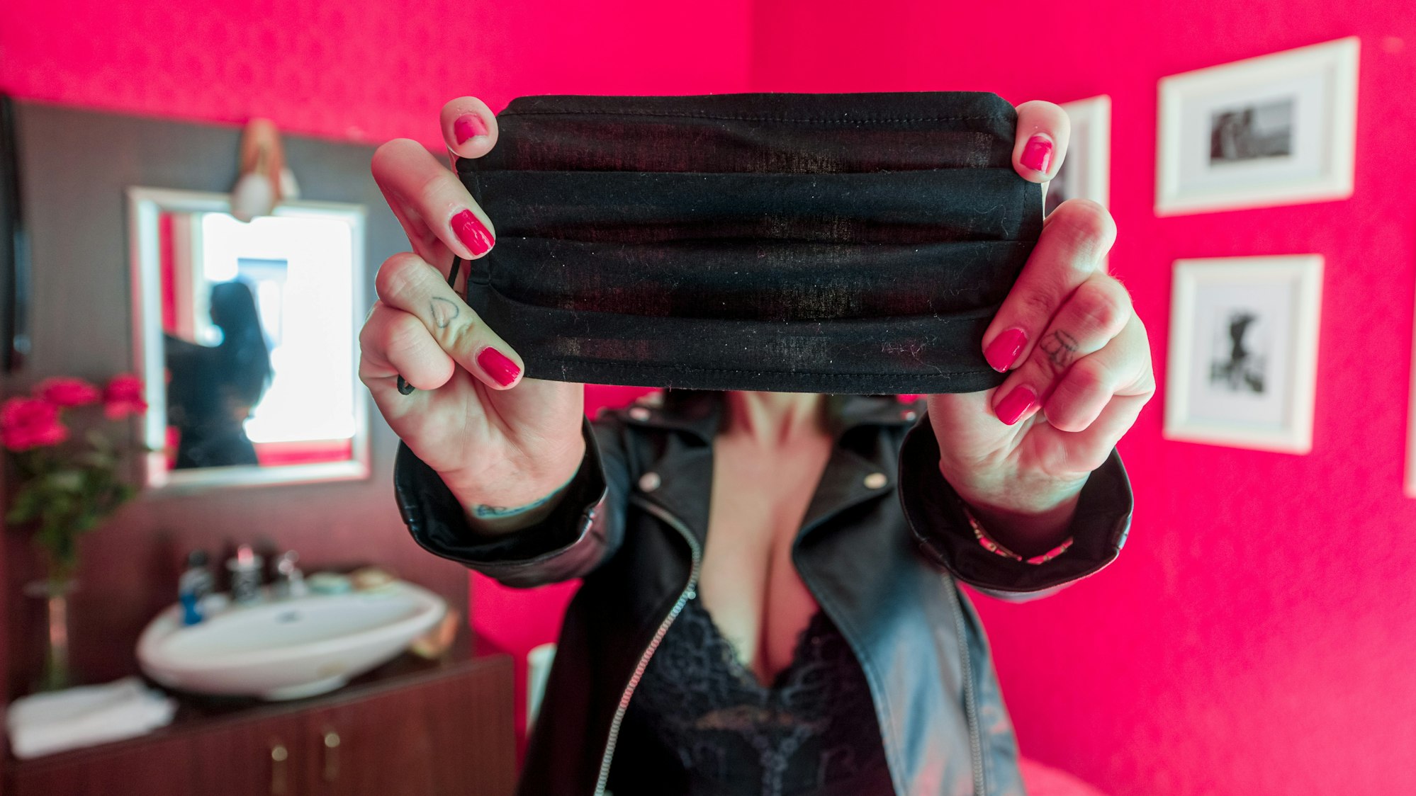 Eine Prostituierte aus Hamburg verdeckt in unserem Symbolbild mit einer Mund-Nasen-Maske an ihrem Arbeitsplatz ihr Gesicht. Per Eilantrag gehen nicht nur Clubbetreiber, sondern auch Bordellbesitzer aus NRW gegen die schärferen Corona-Regeln in Clubs vor.