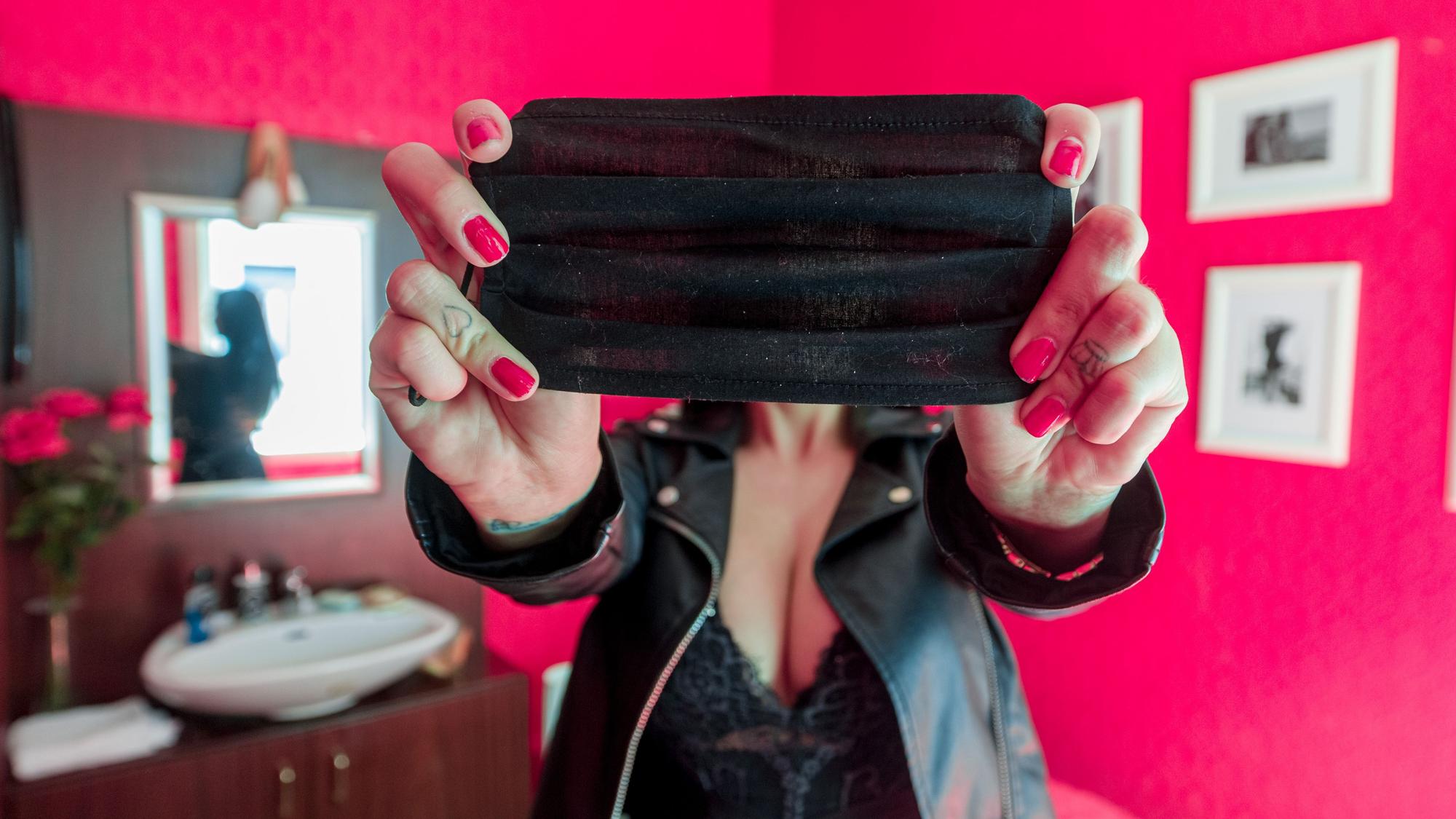 Eine Prostituierte aus Hamburg verdeckt in unserem Symbolbild mit einer Mund-Nasen-Maske an ihrem Arbeitsplatz ihr Gesicht. Per Eilantrag gehen nicht nur Clubbetreiber, sondern auch Bordellbesitzer aus NRW gegen die schärferen Corona-Regeln in Clubs vor.