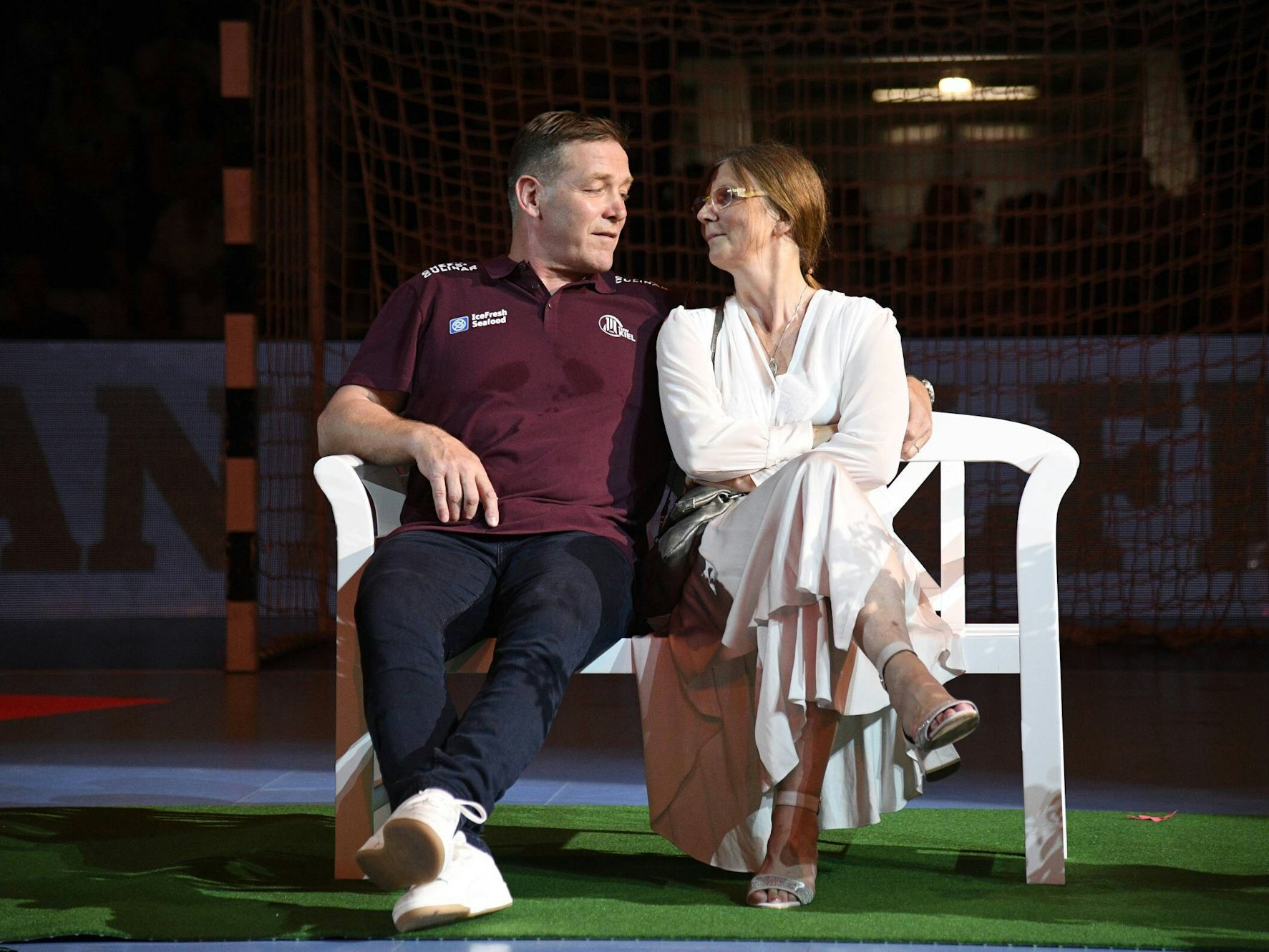 Trainer Alfred Gislason sitzt mit Ehefrau Kara bei seinem Abschiedsspiel für den THW Kiel auf einer Bank.