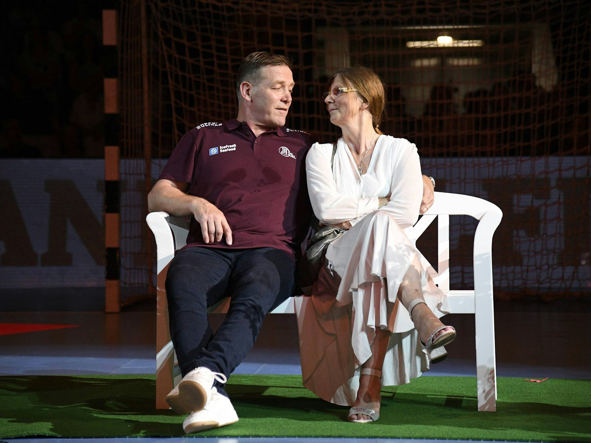 Trainer Alfred Gislason sitzt mit Ehefrau Kara bei seinem Abschiedsspiel für den THW Kiel auf einer Bank.