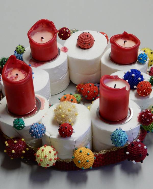 Ein Adventskranz auch acht Klopapierrollen, vier Kerzen und gehäkelten Corona-Viren.