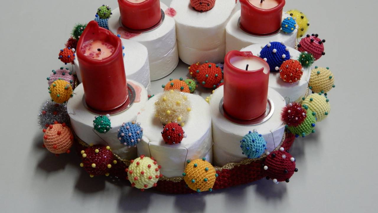Ein Adventskranz auch acht Klopapierrollen, vier Kerzen und gehäkelten Corona-Viren.
