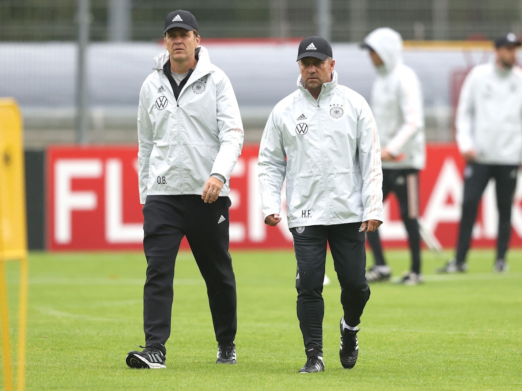 Oliver Bierhoff und Hansi Flick gehen gemeinsam über den Platz beim Training.
