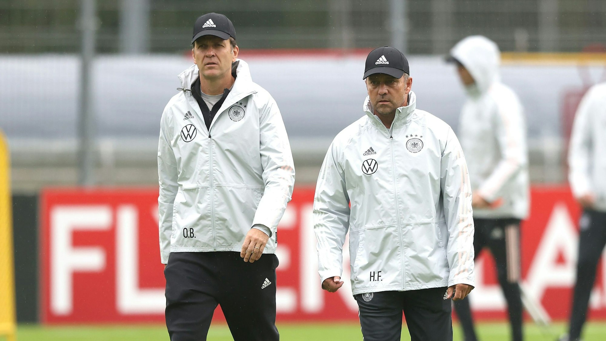 Oliver Bierhoff und Hansi Flick gehen gemeinsam über den Platz beim Training.