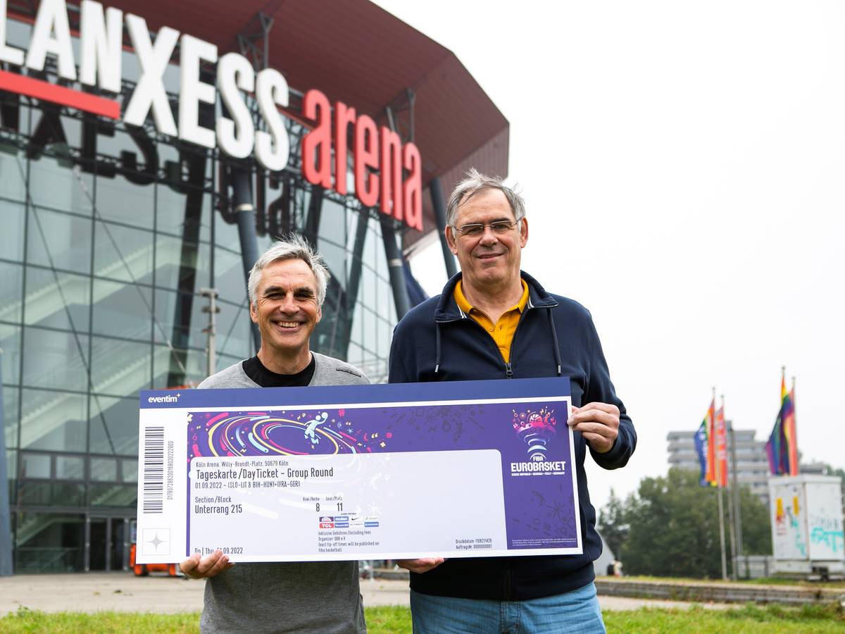 Ein Jahr vor dem Turnierstart: Die Kölner Basketball-Legenden Stefan Baeck und Klaus Zander präsentieren ein symbolisches Ticket für die Basketball-EM 2022 in Köln und Berlin.