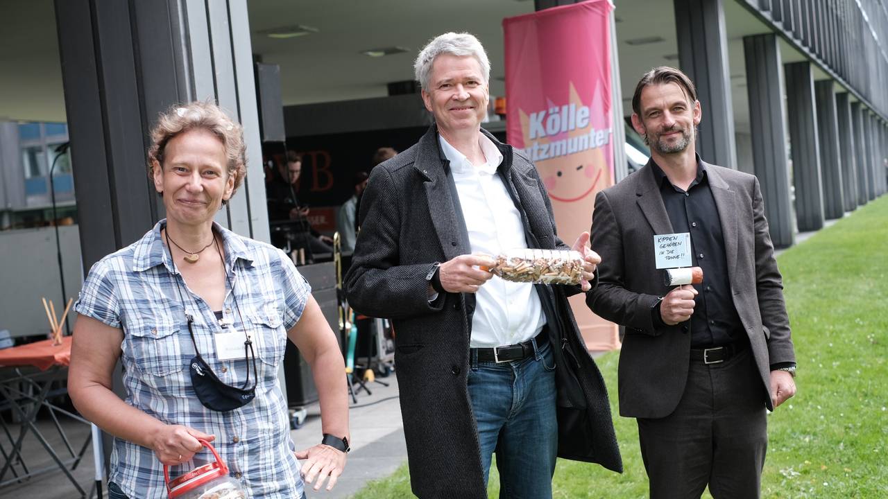 Richarda Fesl, Harald Rau und William Wolfgramm halten Dosen mit Zigarettenkippen in den Händen.