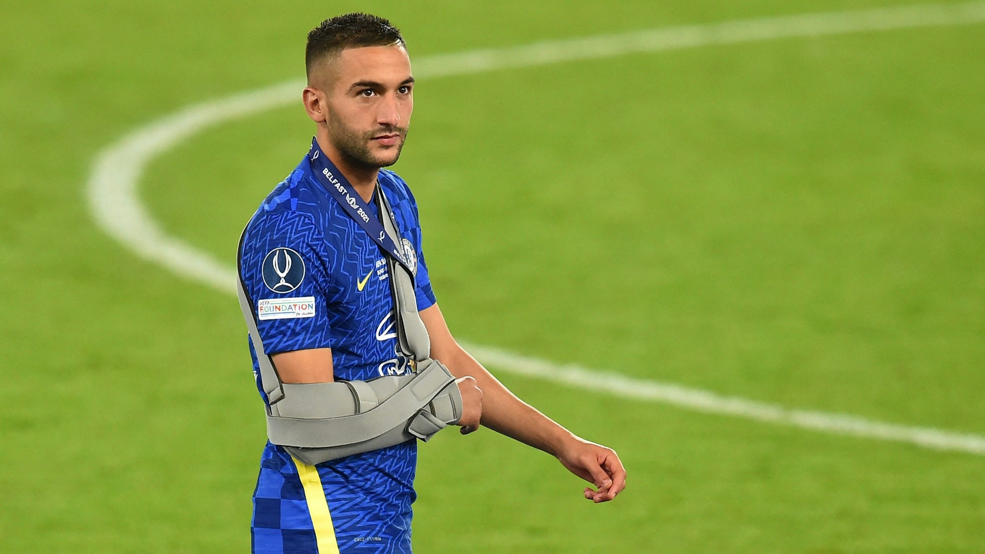 Hakim Ziyech mit einer Schulterstütze auf dem Rasen