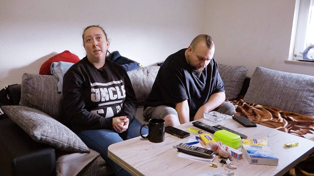 Petra und Sascha sitzen an ihrem Wohnzimmertisch in Mannheim.