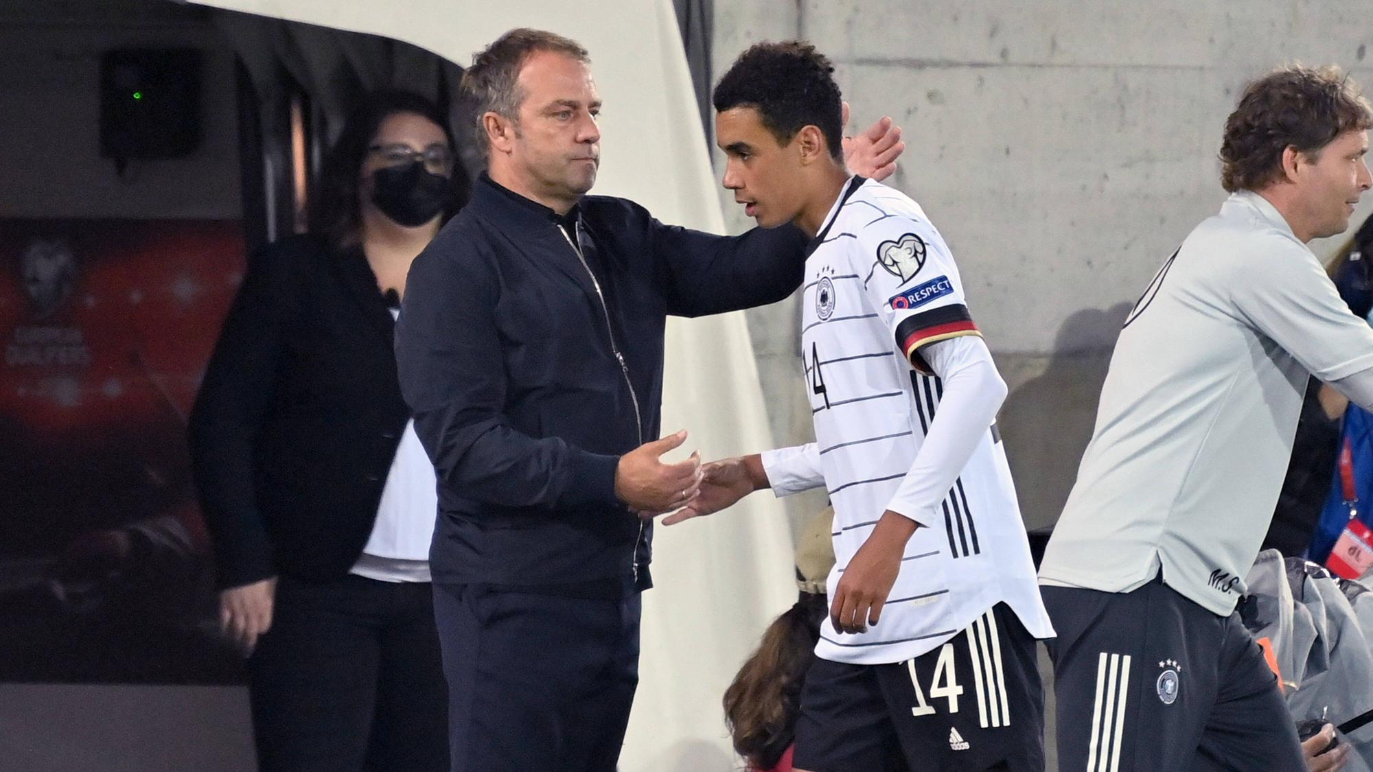Bundestrainer Hansi Flick klatscht Jamal Musiala bei dessen Auswechslung ab.