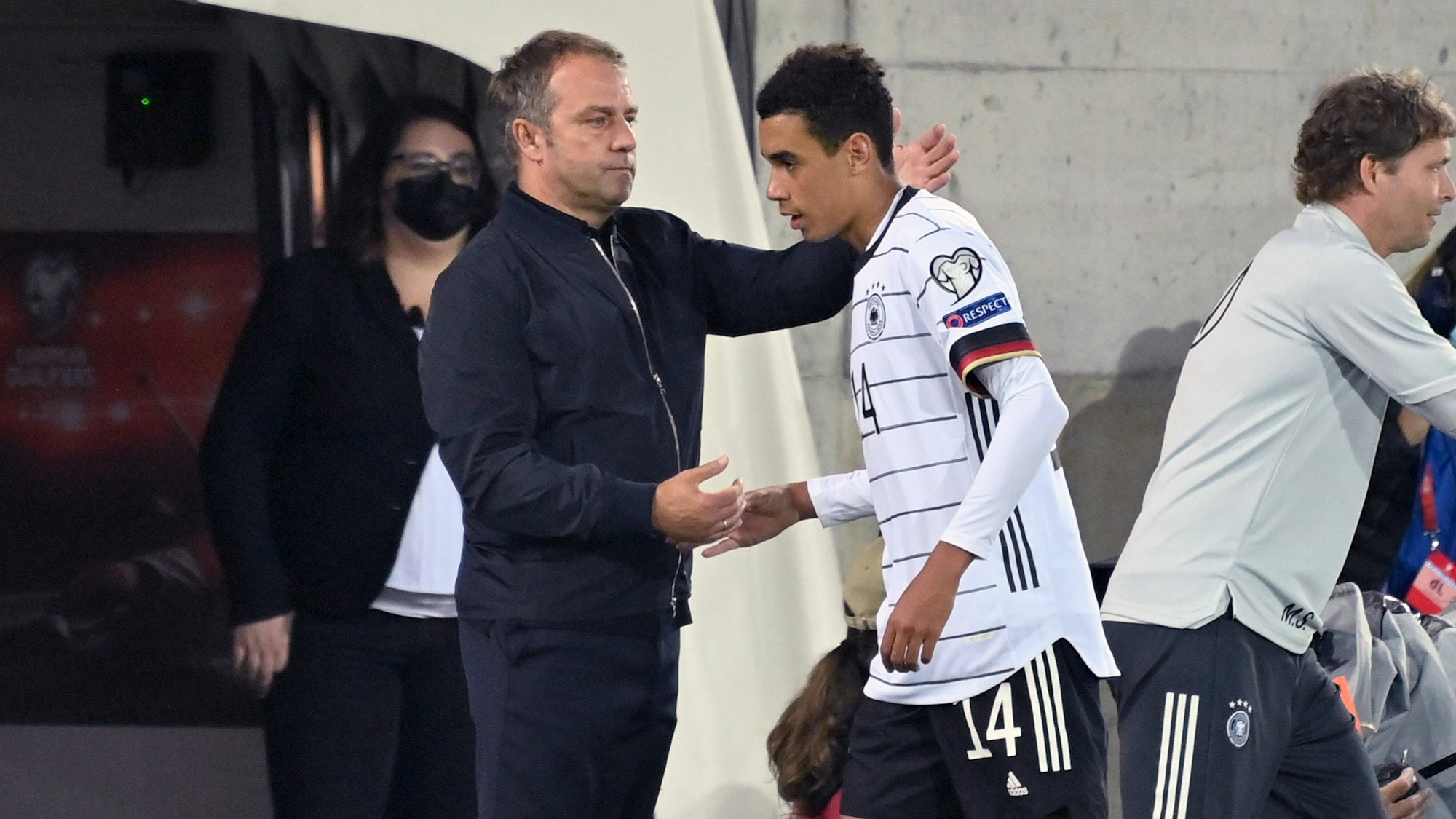 Bundestrainer Hansi Flick klatscht Jamal Musiala bei dessen Auswechslung ab.