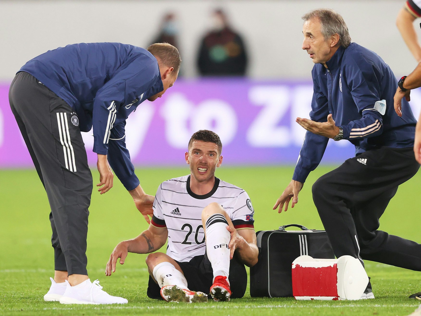Robin Gosens sitzt verletzt auf dem Platz und wird von den Medizinern betreut.