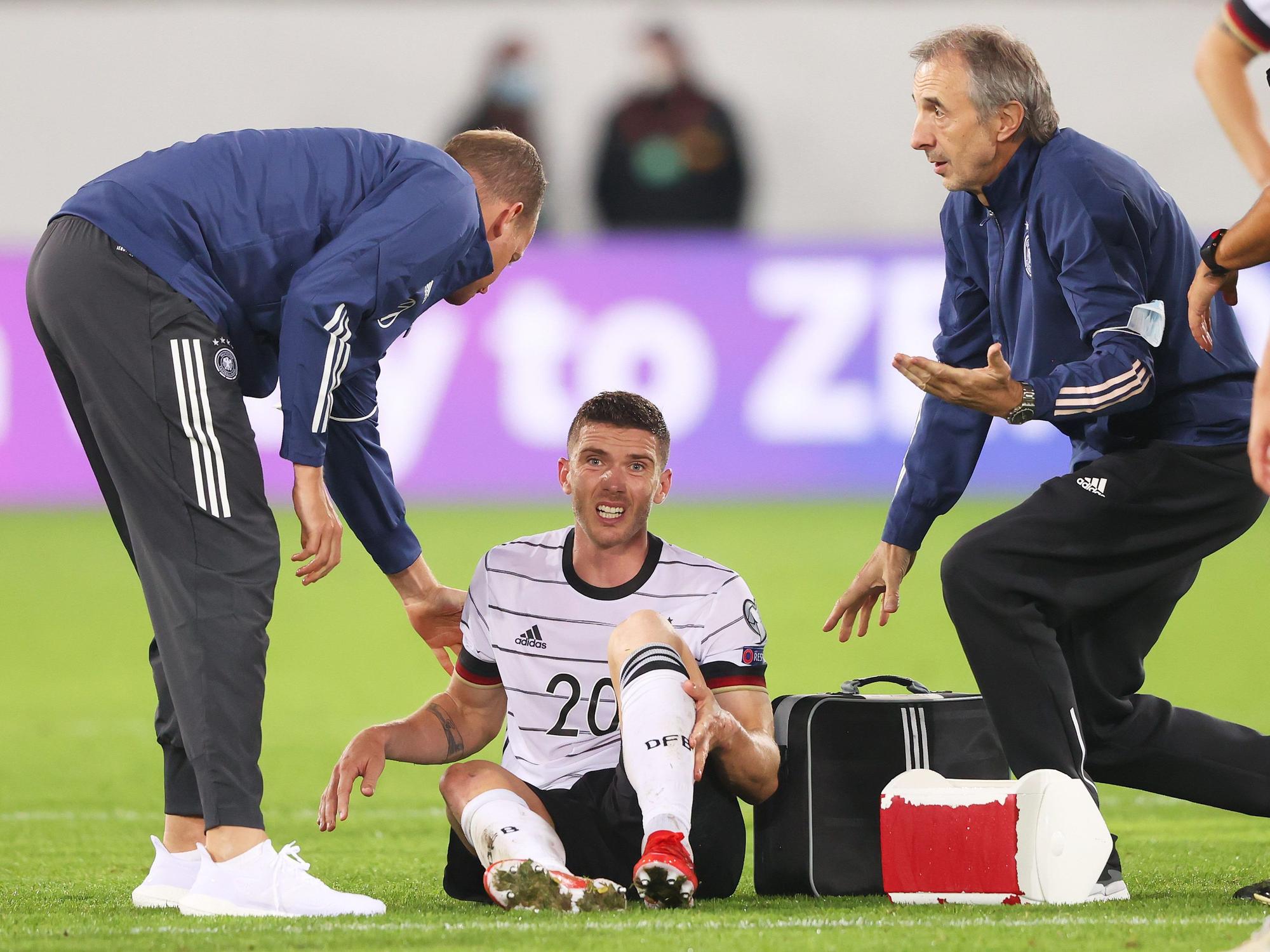 Robin Gosens sitzt verletzt auf dem Platz und wird von den Medizinern betreut.
