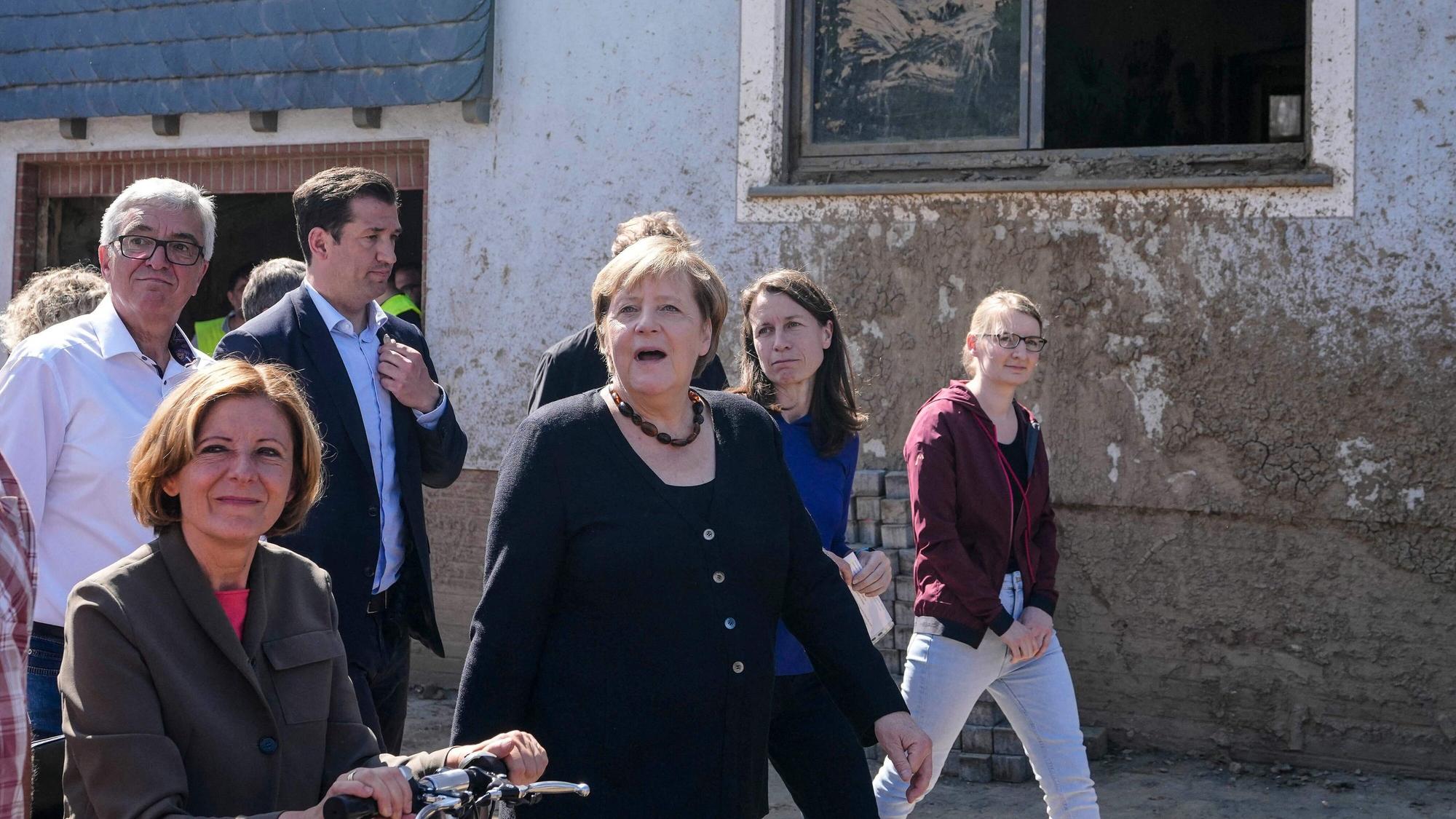 German Chancellor Angela Merkel, center, and Malu Dreyer, left, Prime Minister of Rhineland-Palatinate, talk to residents during their visit to the flood-damaged district Altenburg, part of the municipality of Altenahr, Germany, on September 3, 2021. - After days of extreme downpours, devastating floods hit the valley of the river Ahr in July 2021. (Photo by Markus Schreiber / POOL / AFP)