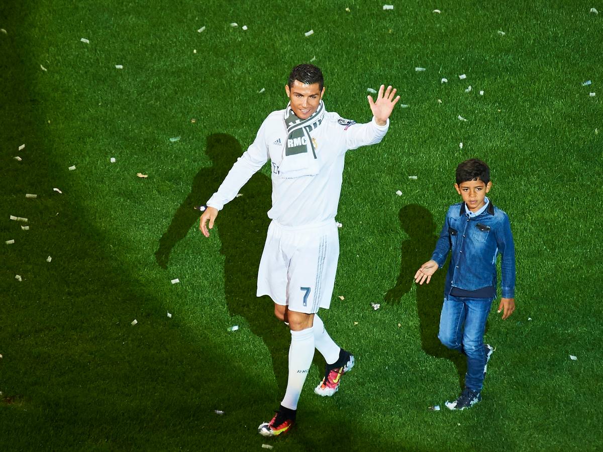 Cristiano Ronaldo und sein Sohn Cristiano Jr. laufen über den Platz von Real Madrid.