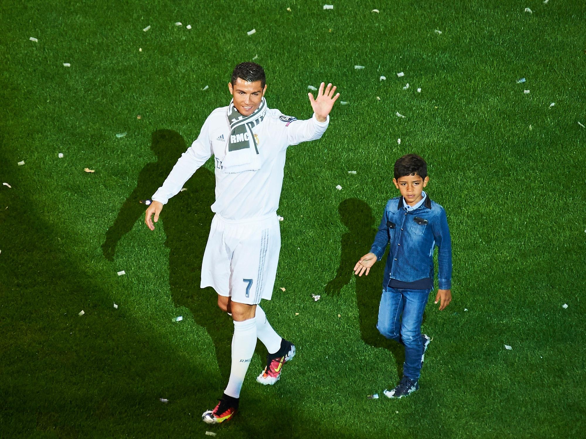 Cristiano Ronaldo und sein Sohn Cristiano Jr. laufen über den Platz von Real Madrid.