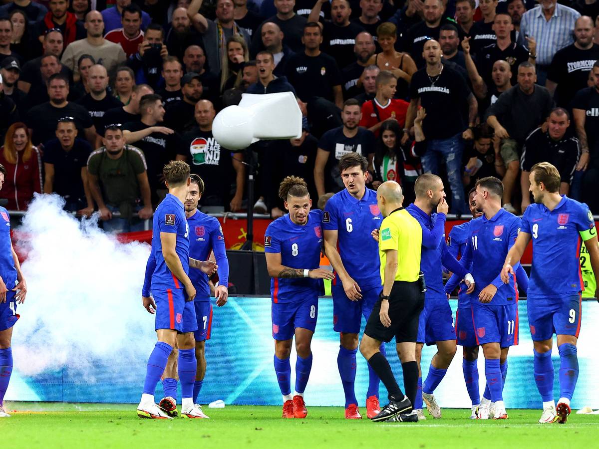 Englische Spieler stehen vor ungarischem Publikum, das sie beschimpft.