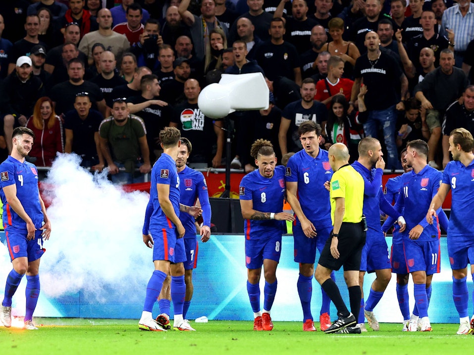 Englische Spieler stehen vor ungarischem Publikum, das sie beschimpft.