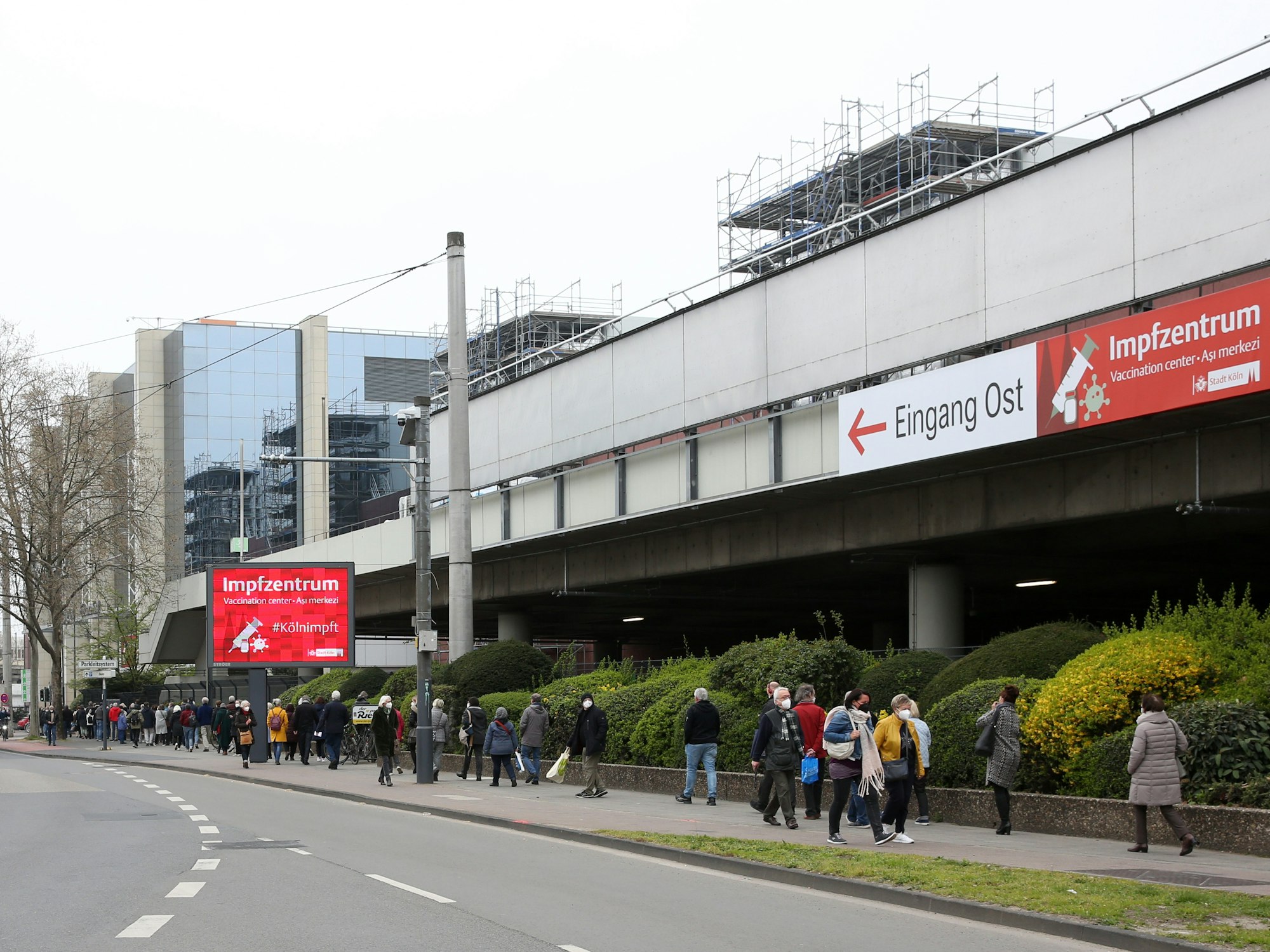 Menschen warten vor dem Impfzentrum Köln auf ihre Impfung.