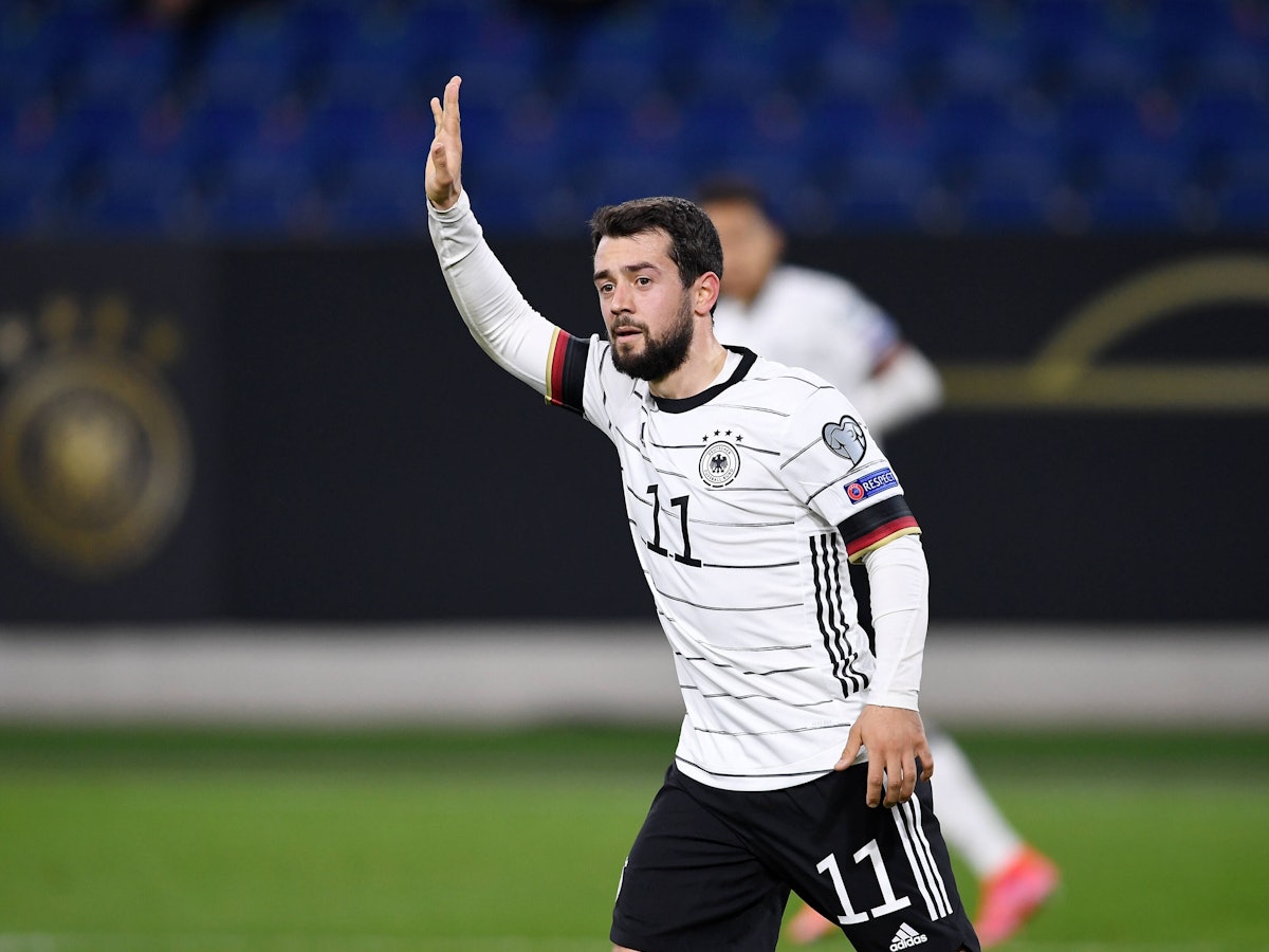 Amin Younes im Trikot der deutschen Nationalmannschaft hebt den Arm.