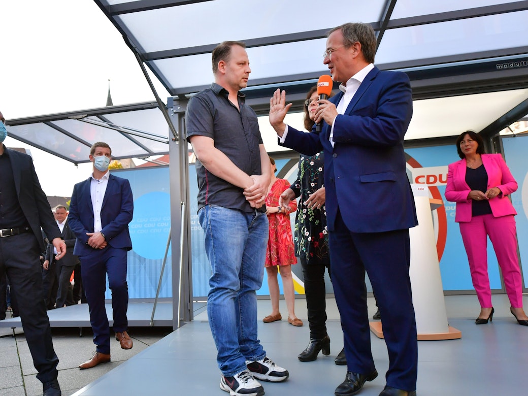 Armin Laschet spricht während einer Veranstaltung in Erfurt am 3. September mit einem Mann, der auf das Podium gesprungen ist.