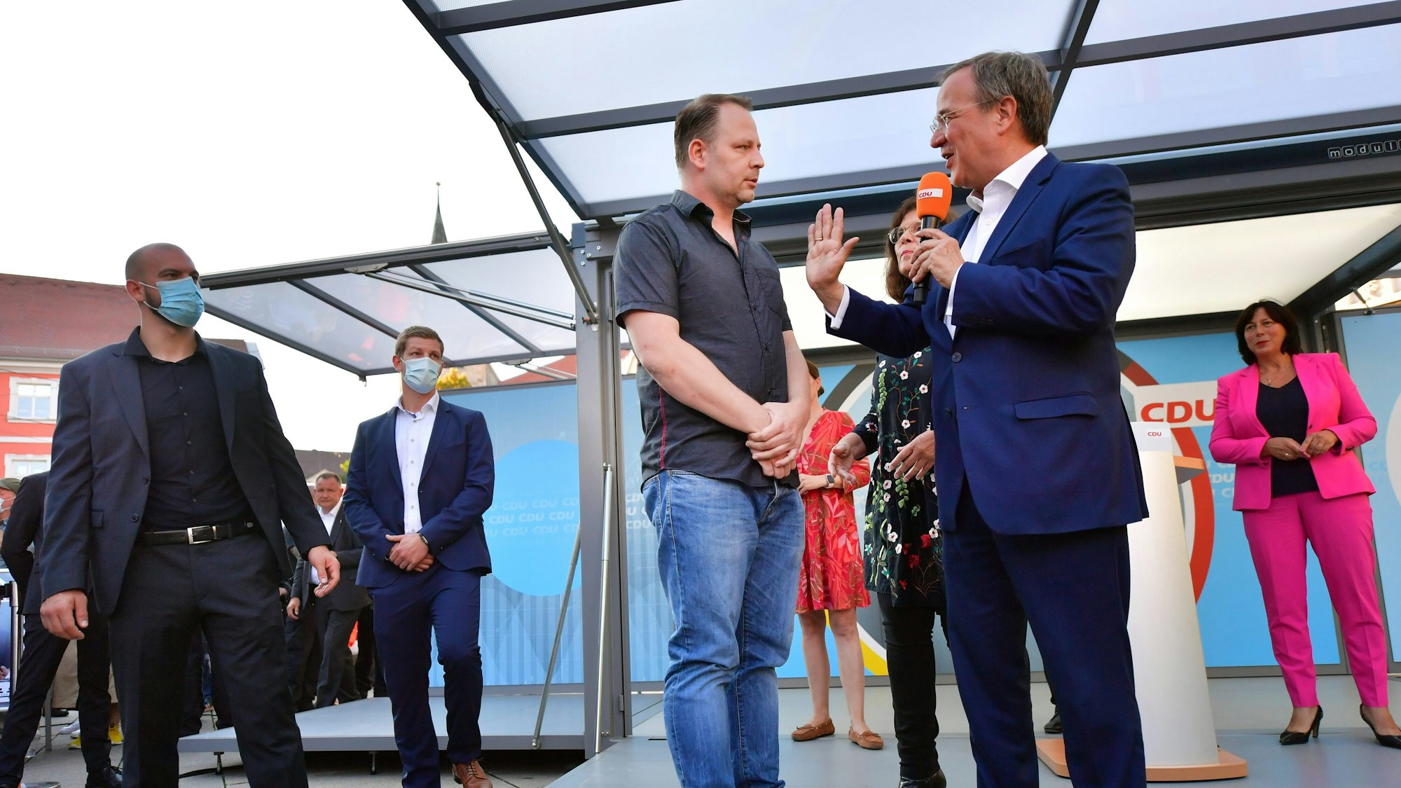 Armin Laschet spricht während einer Veranstaltung in Erfurt am 3. September mit einem Mann, der auf das Podium gesprungen ist.