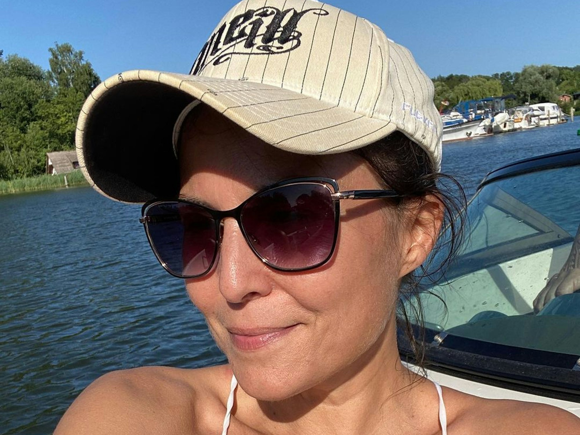 „Sat.1-Frühstücksfernsehen“-Moderatorin Vanessa Blumhagen posiert im Bikini, mit Kappe und Sonnenbrille auf einem Boot für ein Foto.