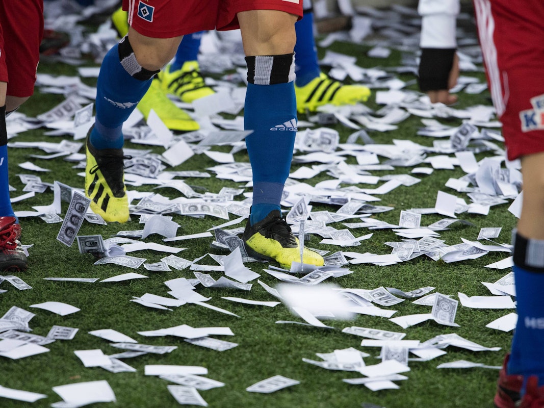 Auf dem Boden des Volksparkstadions in Hamburg liegen viele Spielgeldscheine.