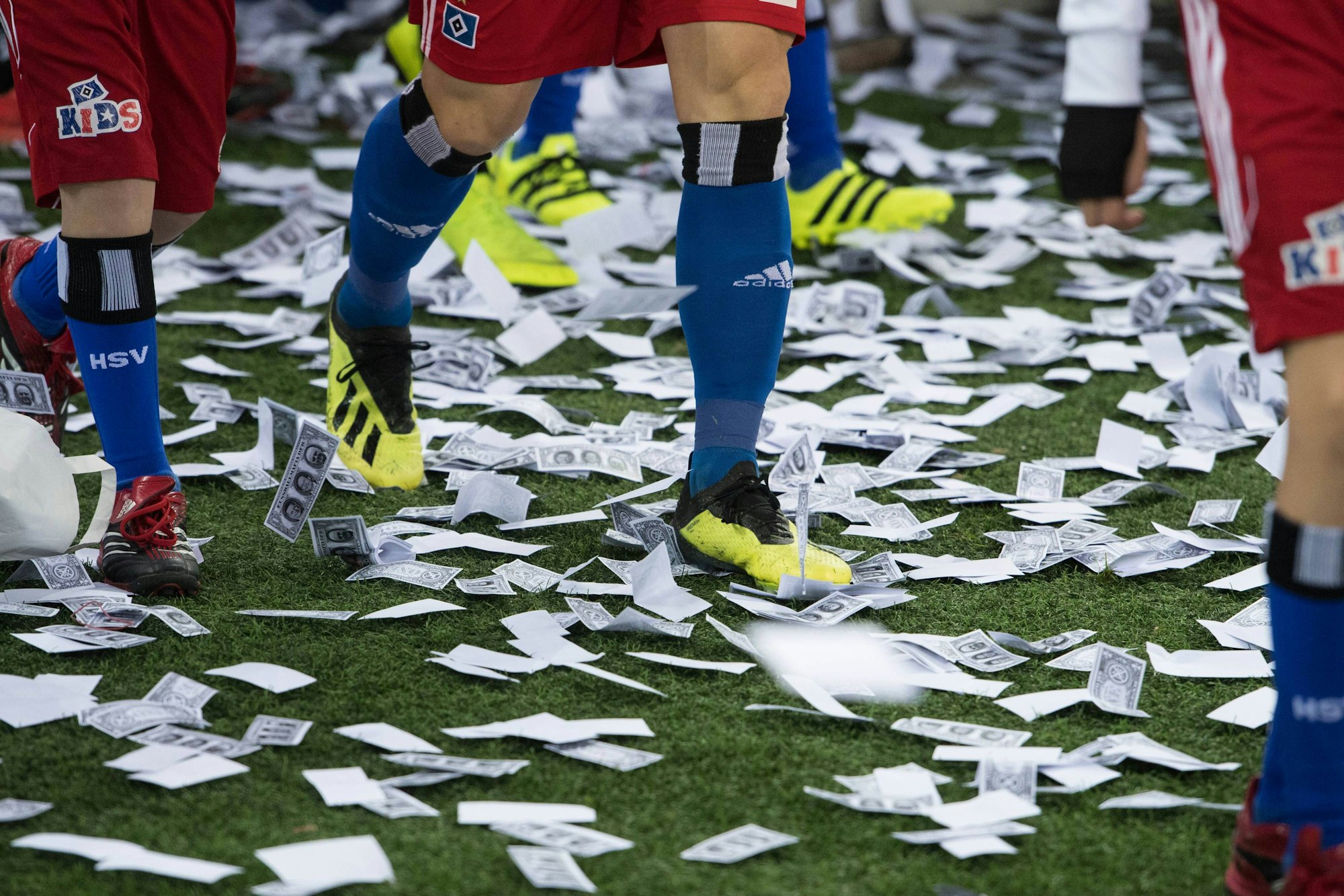 Auf dem Boden des Volksparkstadions in Hamburg liegen viele Spielgeldscheine.