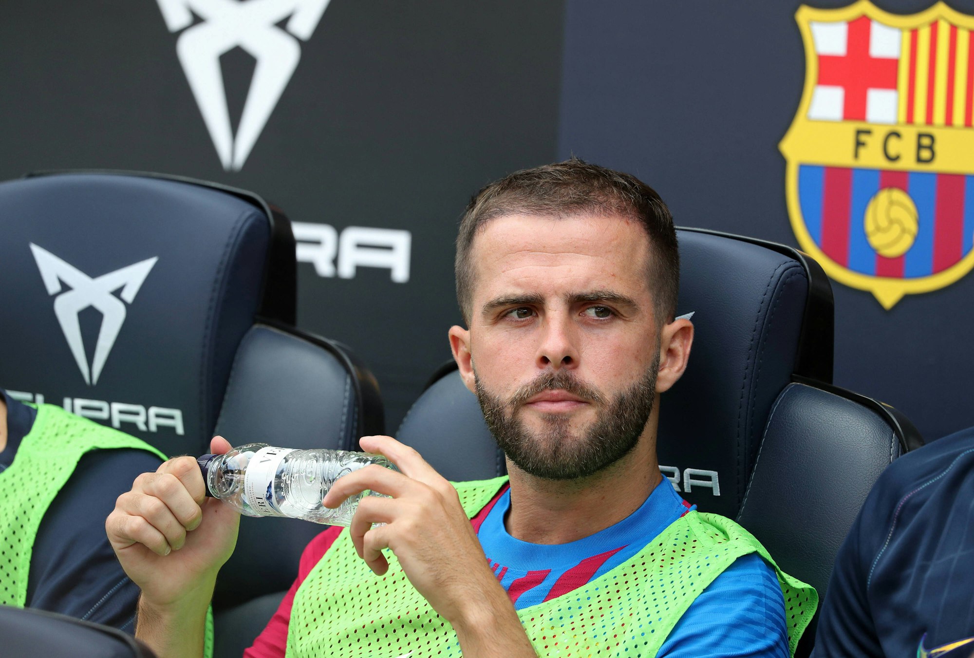 Pjanic sitzt auf der Reservebank, hält eine Flasche in beiden Händen und guckt zur Seite.