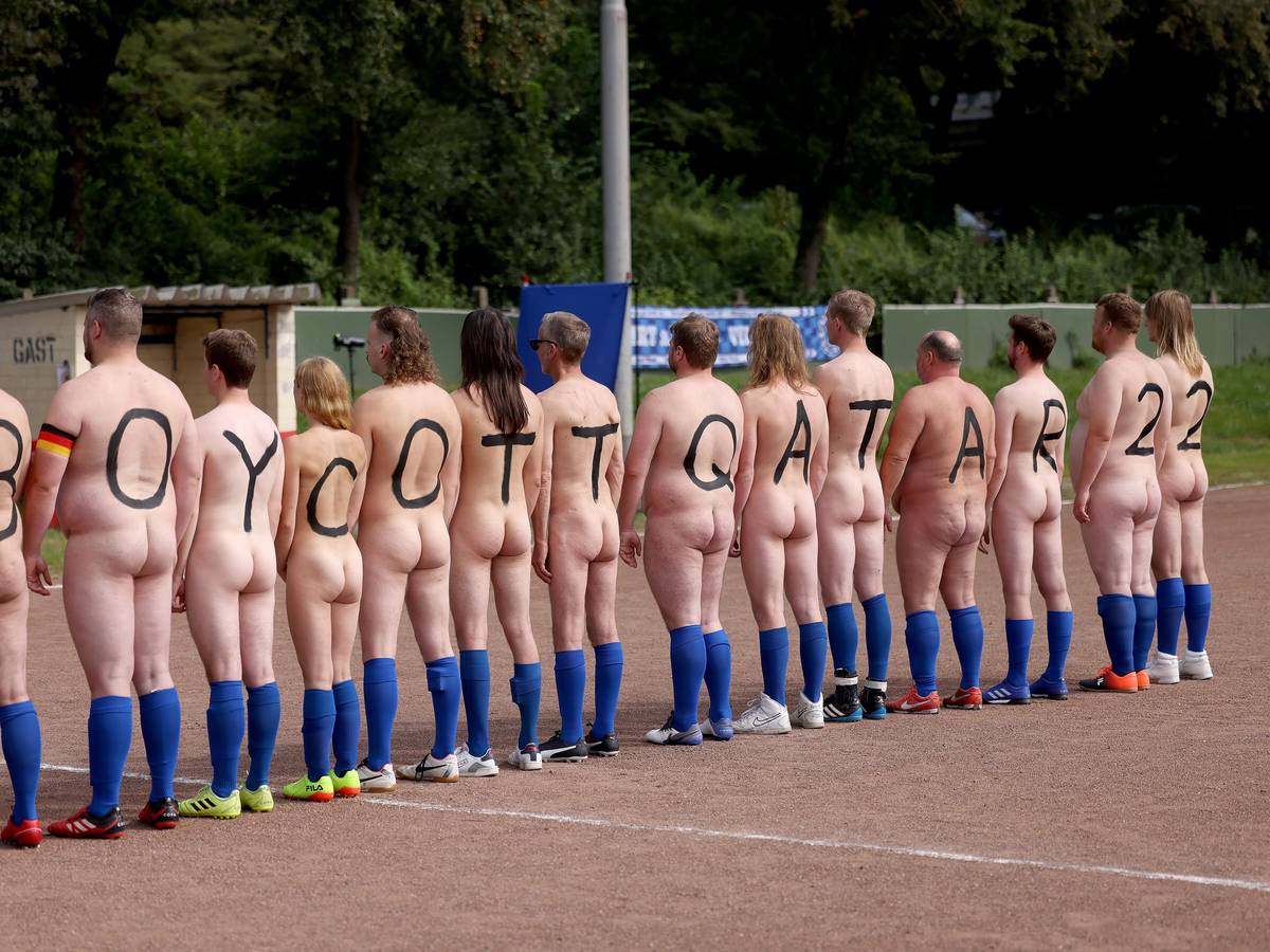 14 nackte Spielerinnen und Spieler drehen ihre Rücken zur Kamera. Sie tragen jeweils einen Buchstaben bzw. eine Ziffer auf dem Rücken. Zu lesen ist: Boycott Qatar 22.