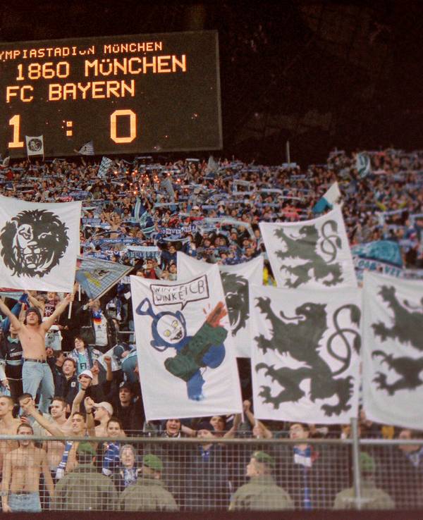 Auf der Anzeigetafel steht, dass 1860 mit 1:0 gegen Bayern gewonnen hat. Darunter freuen sich die Fans der Löwen.
