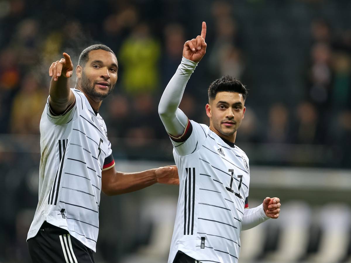 Nadiem Amiri und Jonathan Tah heben ihre Zeigefinger.
