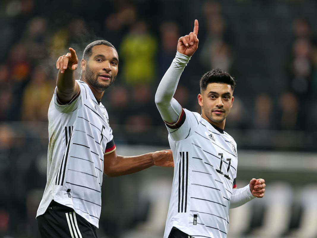 Nadiem Amiri und Jonathan Tah heben ihre Zeigefinger.