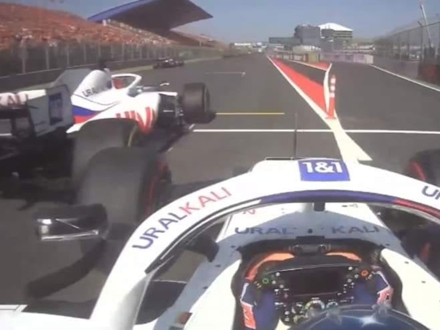 Haas-Russe Nikita Mazepin drängt Mick Schumacher am Ende der 1. Runde Richtung Boxenmauer.