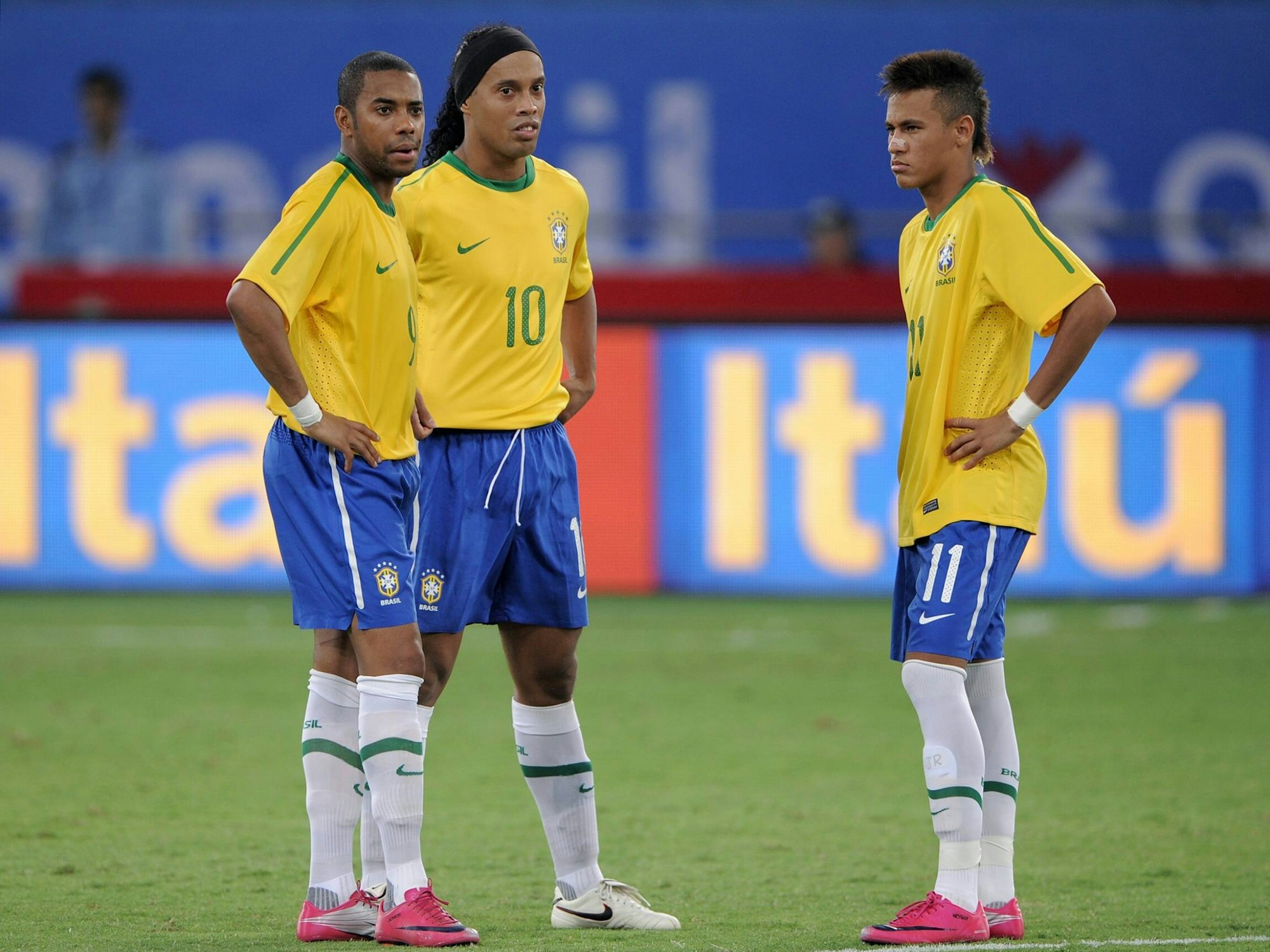 Robinho, Ronaldinho und Neymar stehen mit den Händen in den Hüften auf dem Feld.