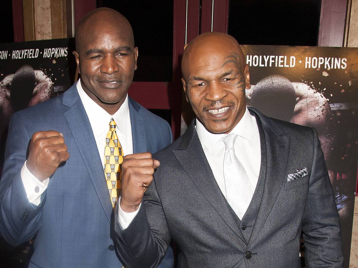 Evander Holyfield und Mike Tyson ballen die Fäuste.