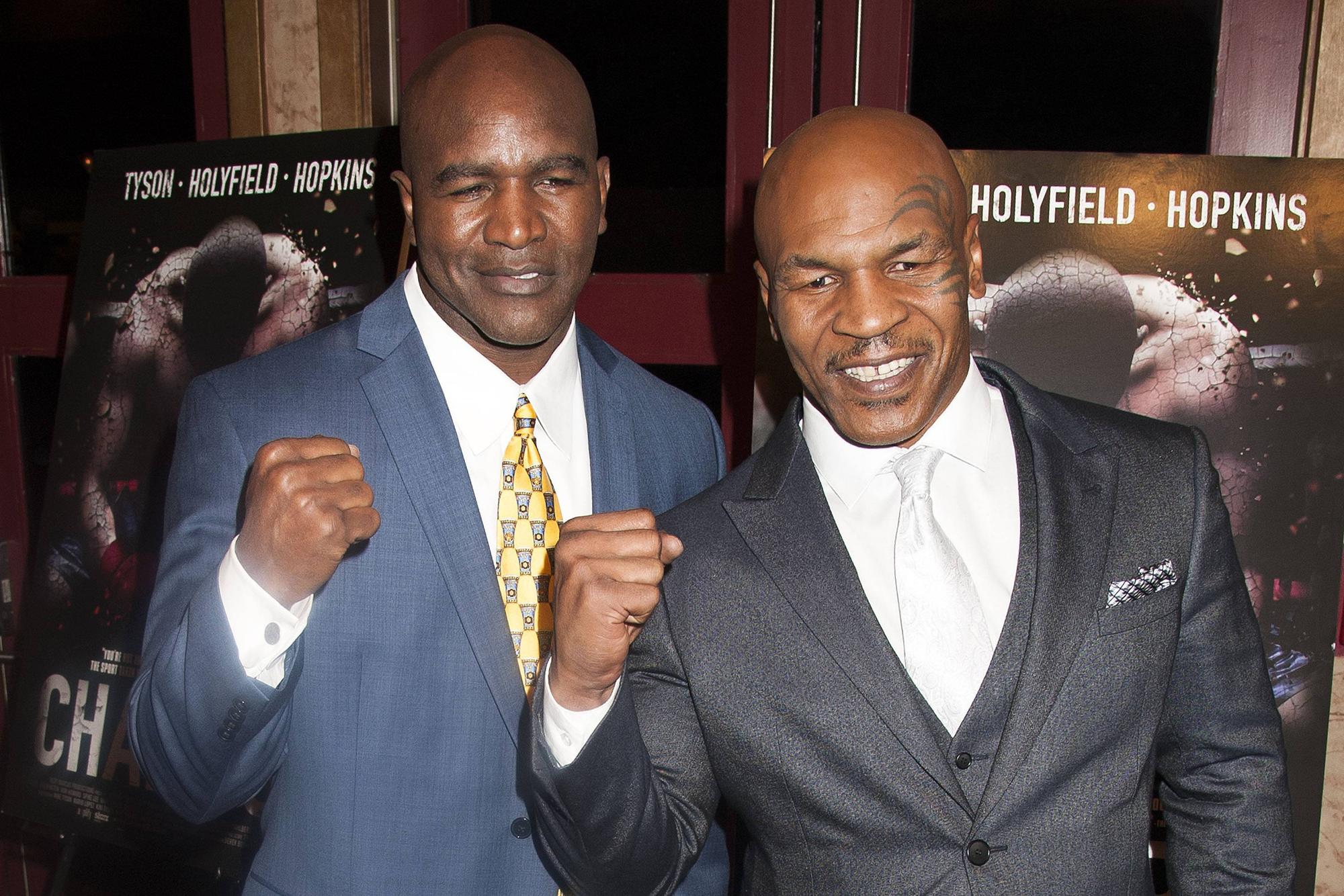 Evander Holyfield und Mike Tyson ballen die Fäuste.