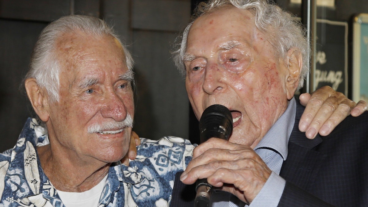 Ludwig Sebus spricht ins Mikrophon, neben ihm Hans Süper.