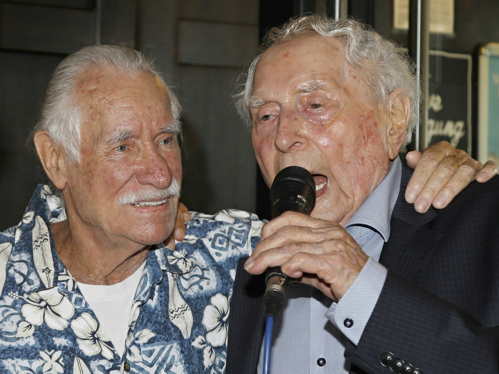 Ludwig Sebus spricht ins Mikrophon, neben ihm Hans Süper.